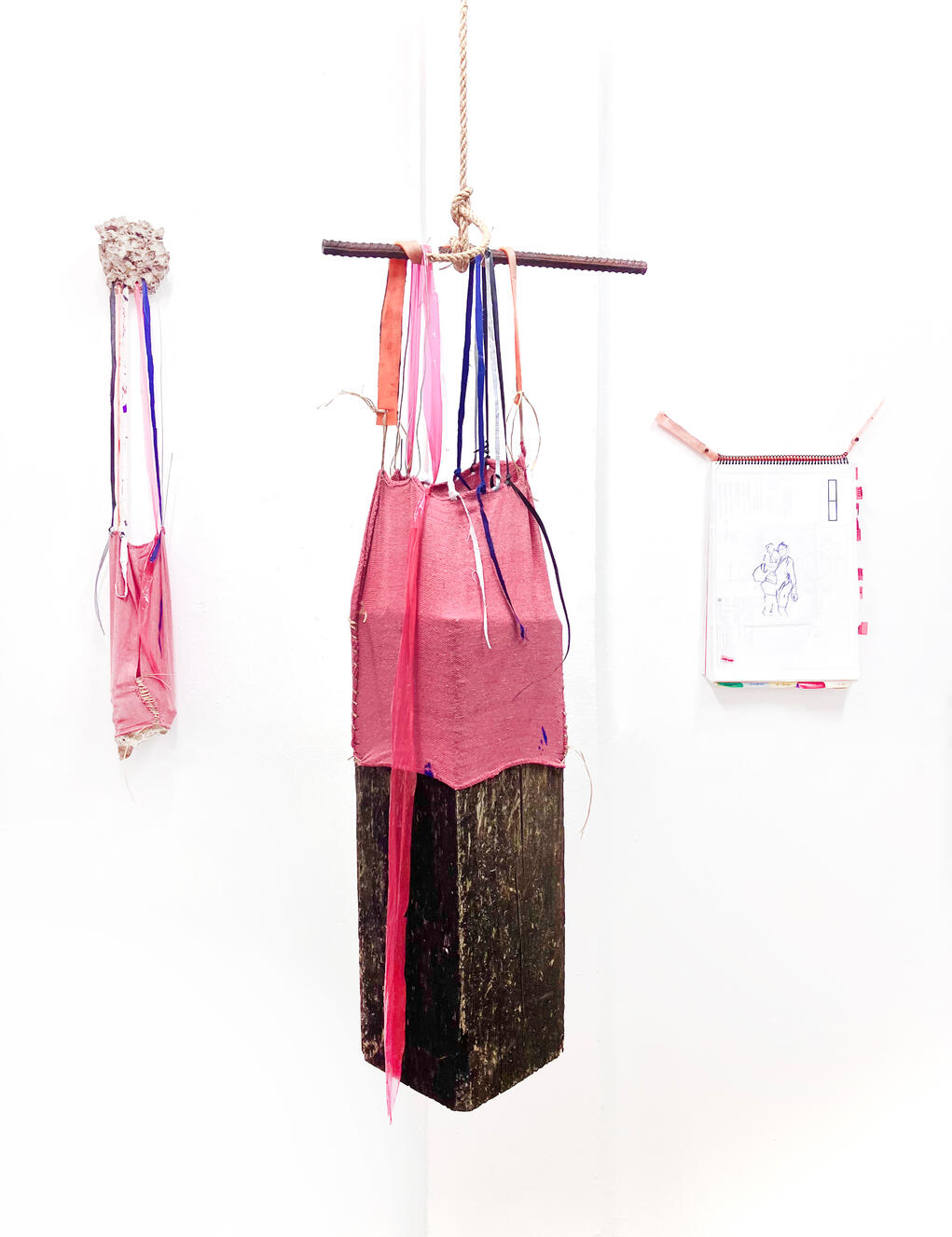 &quot;Railroad Tie and Rag&quot;, 2024, wood, tarp, shop rag, sinew, wire, tar paper, traffic cone, uniform, 17&quot; × 80&quot; × 8&quot;.